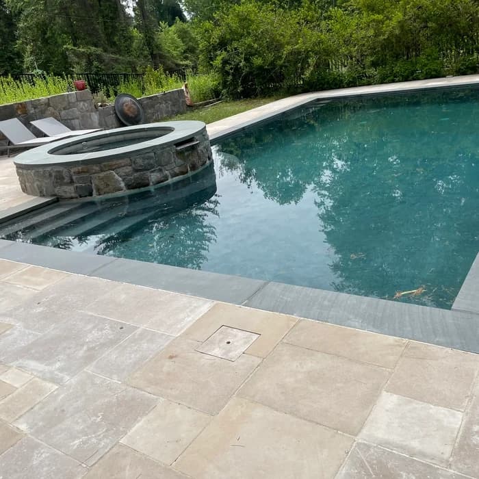 Remodeled backyard pool with raised stone spa and fire bowl feature