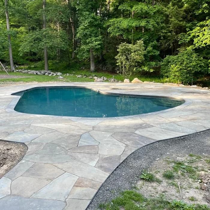 Completed free-form kidney inground pool with bluestone patio