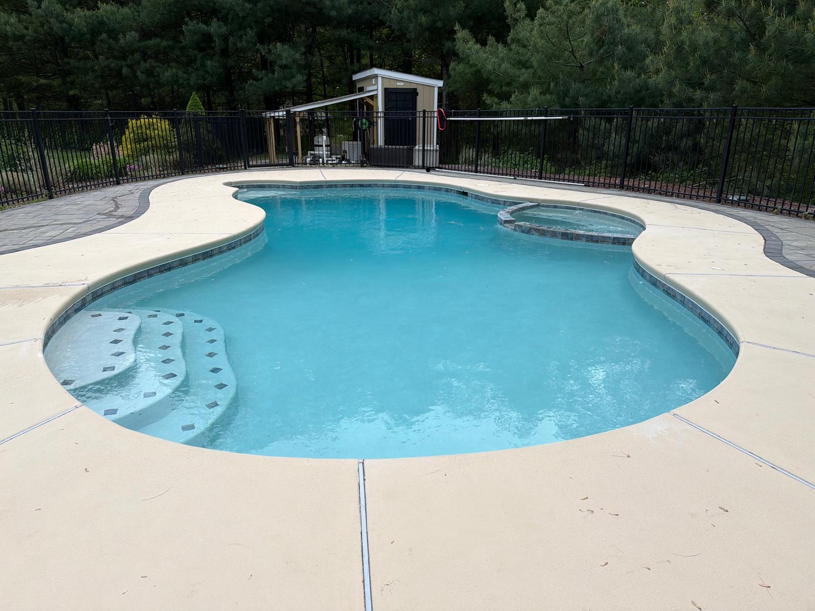Completed kidney pool with raised spa and tan decking, the finished luxury result
